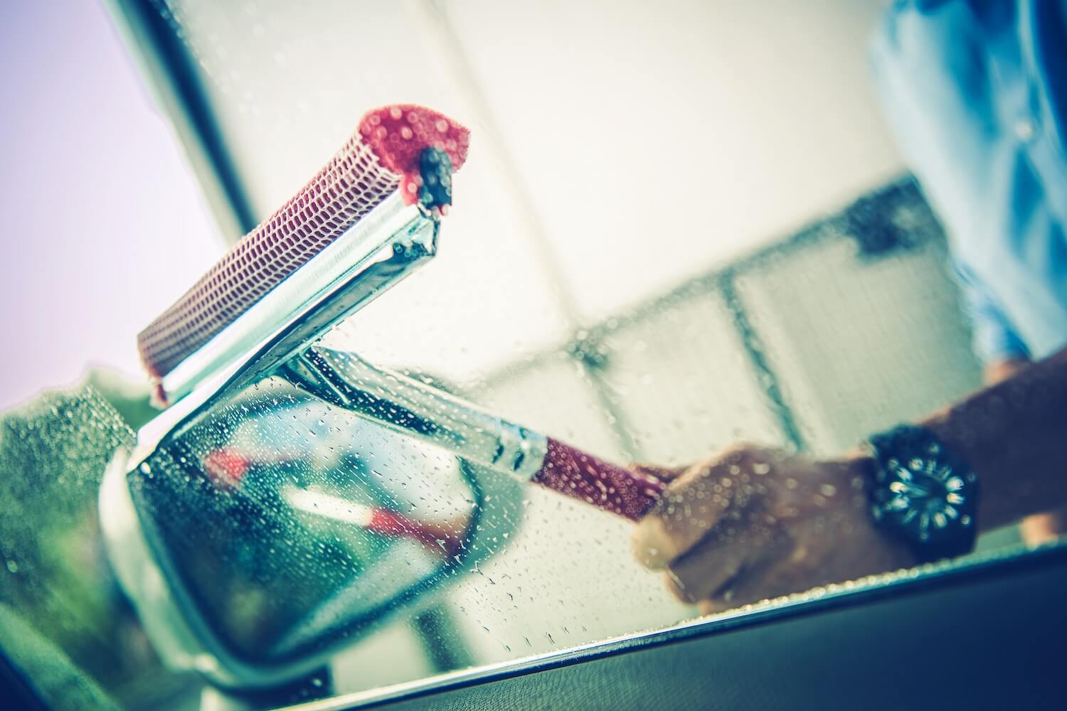 Man Cleaning Car Window With Squeegee