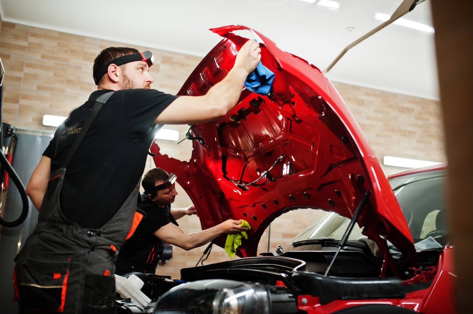 Mechanics Repairing Car Engine At An Auto Shop